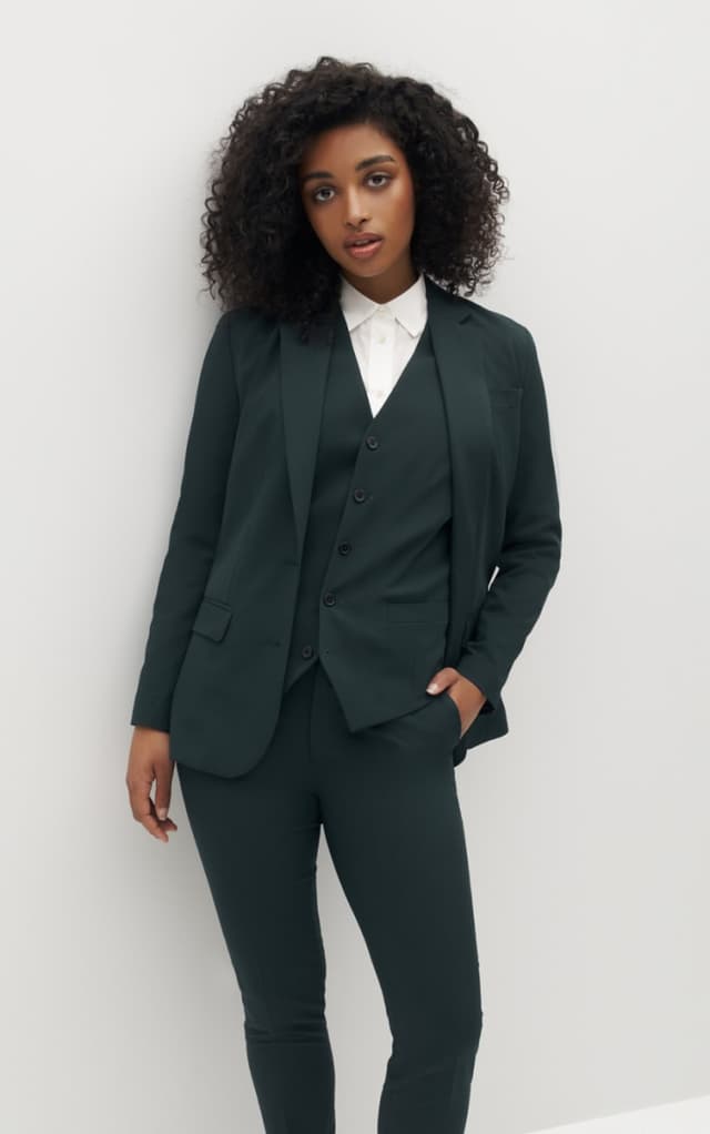 Woman wearing dark green suit with matching vest